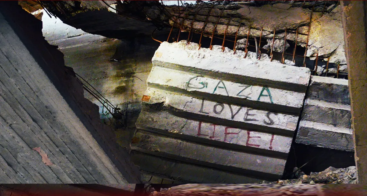 A concrete slab inside a collapsed building with "Gaza Loves Life!" painted on it