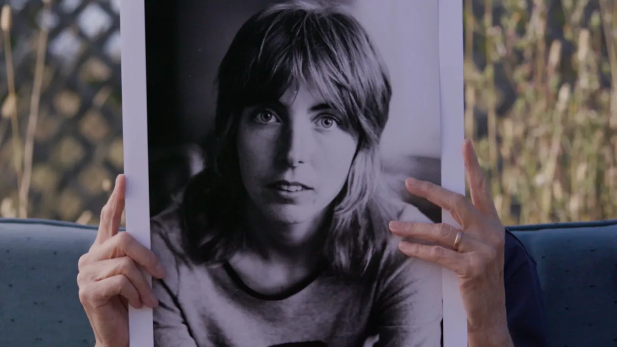 Vivien Hillgrove holding a photo of her younger self.