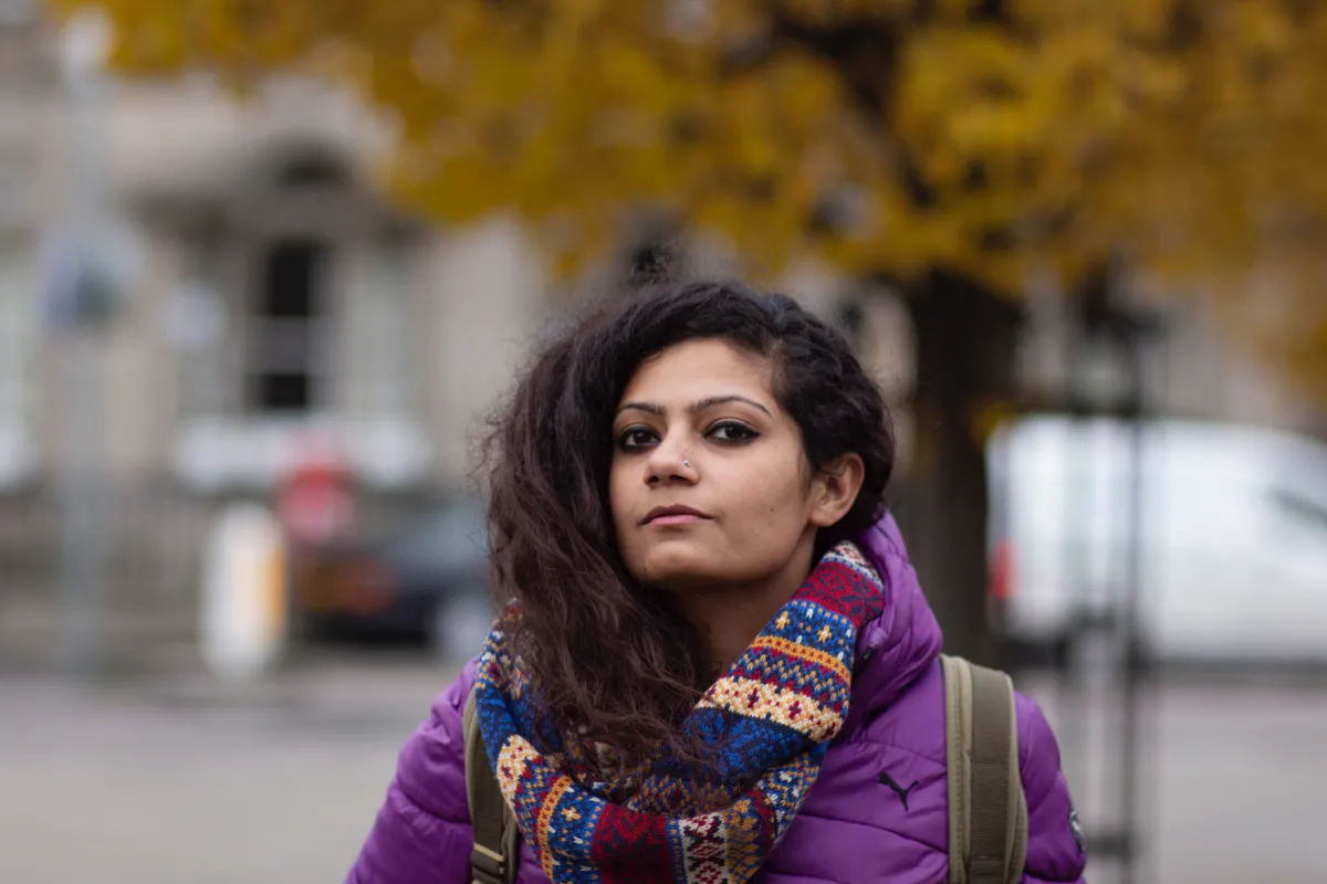 Headshot of Koval Bhatia wearing a large scarf and purple jacket