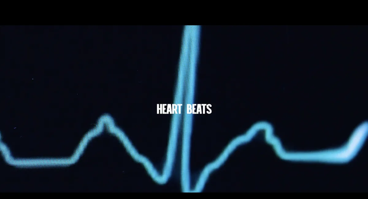 Heart Beats in white lettering over a background of a heart monitoring machine.