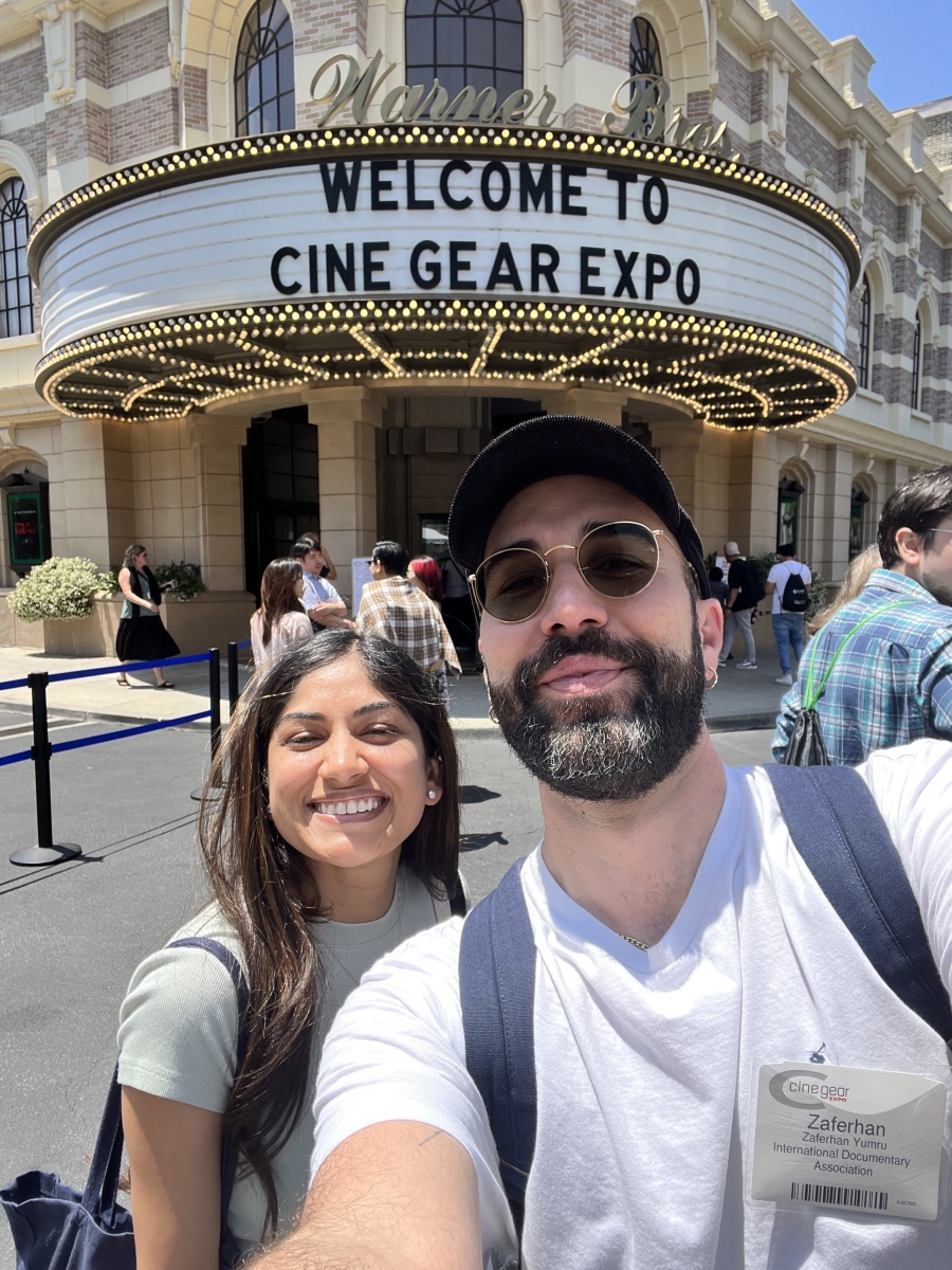 Selfie of a man and woman standing in front of a sign reading “Welcome to Cine Gear Expo.”