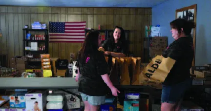 Three organizers in conversation in the food pantry and safe space they created out of a union hall.