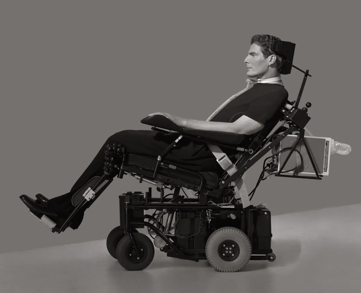 black and white image of a white man in a power chair taken in profile