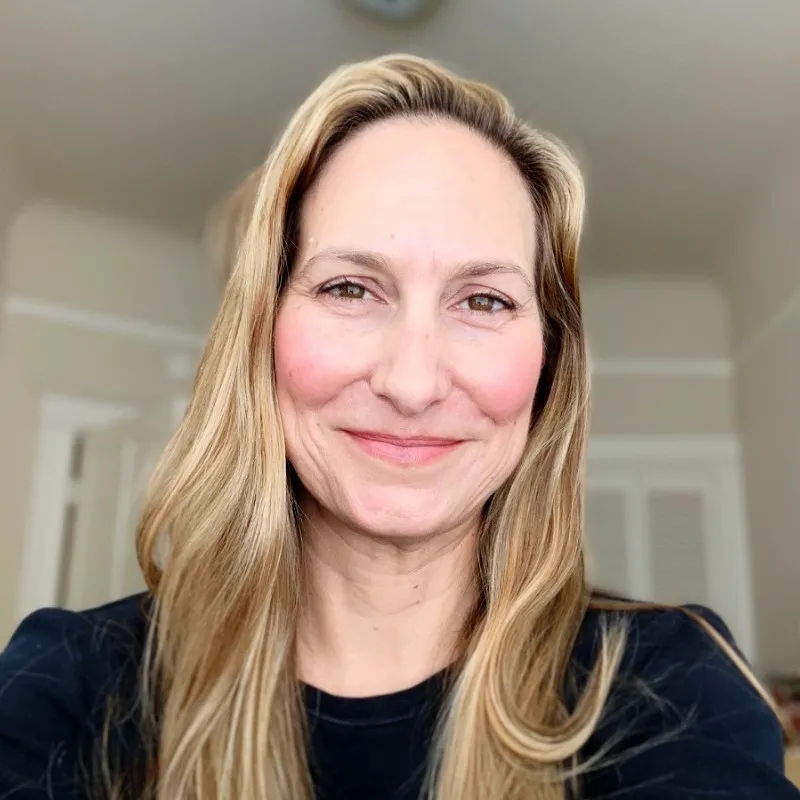 head shot of white woman with blond hair smiling at camera