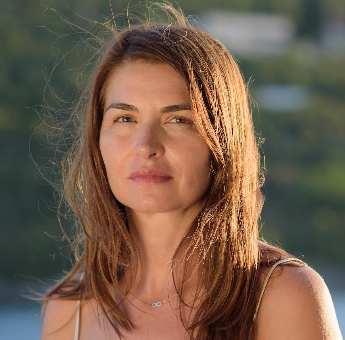 headshot of a white woman with brown hair and light hitting the ide of her face