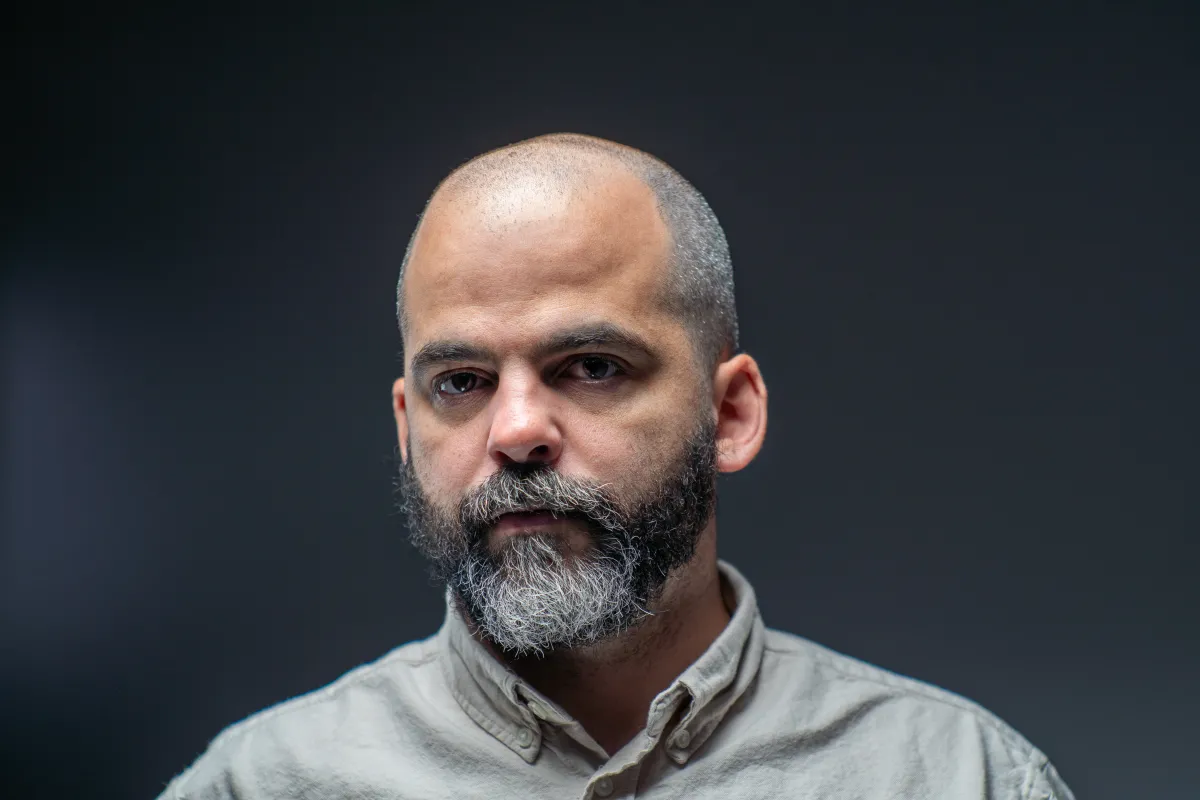 head shot of white man with graying beard over gray background