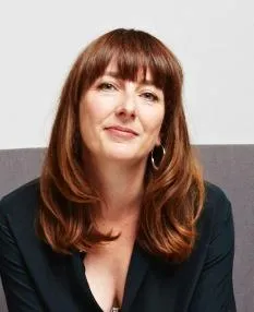 headshot of white woman with red hair with bangs