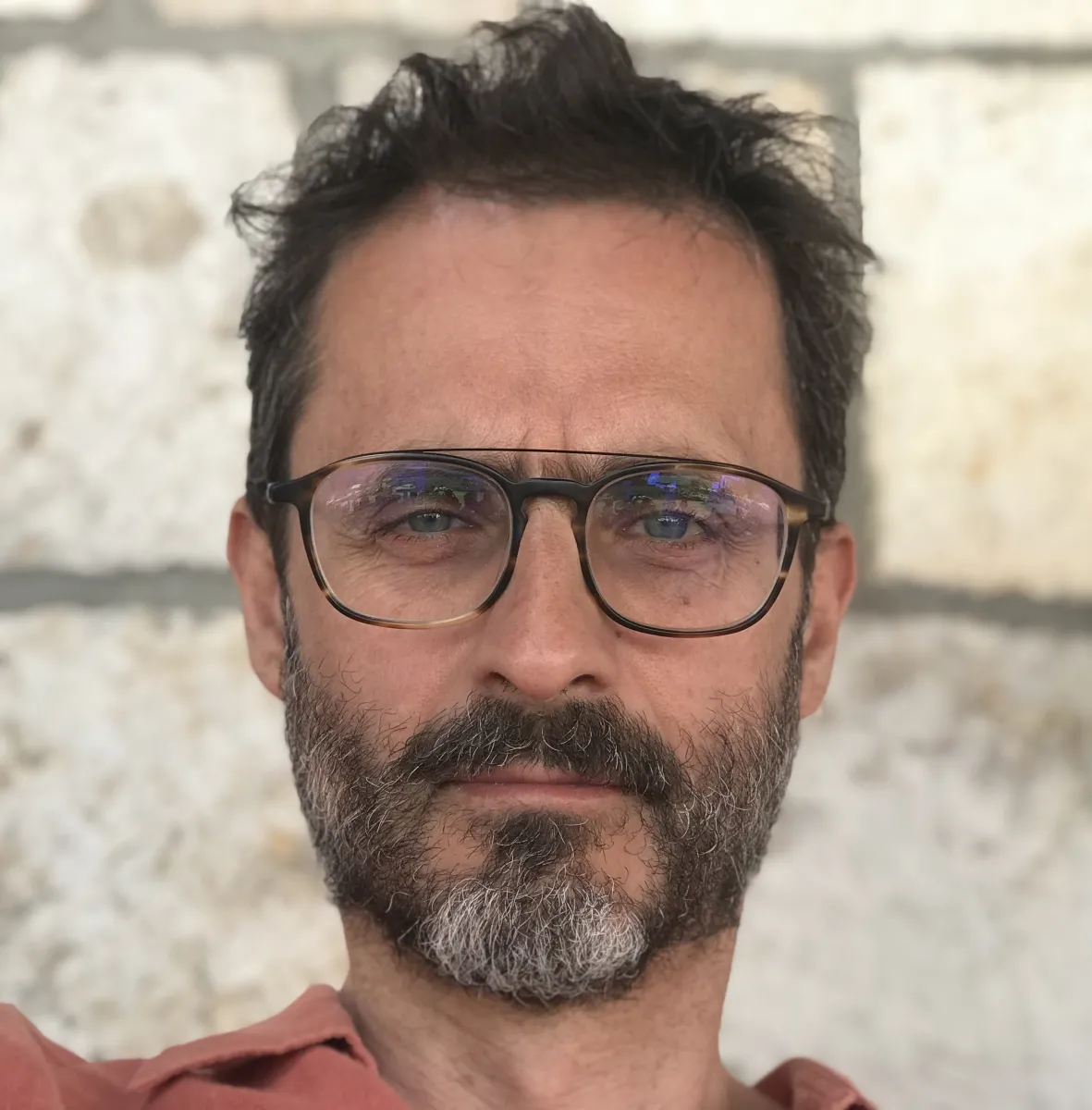 headshot of white man with beard and aviator glasses