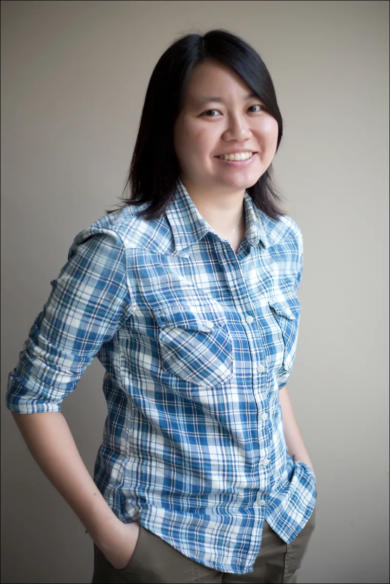 photo of an asain person with long brown ahir and a plaid button up shirt