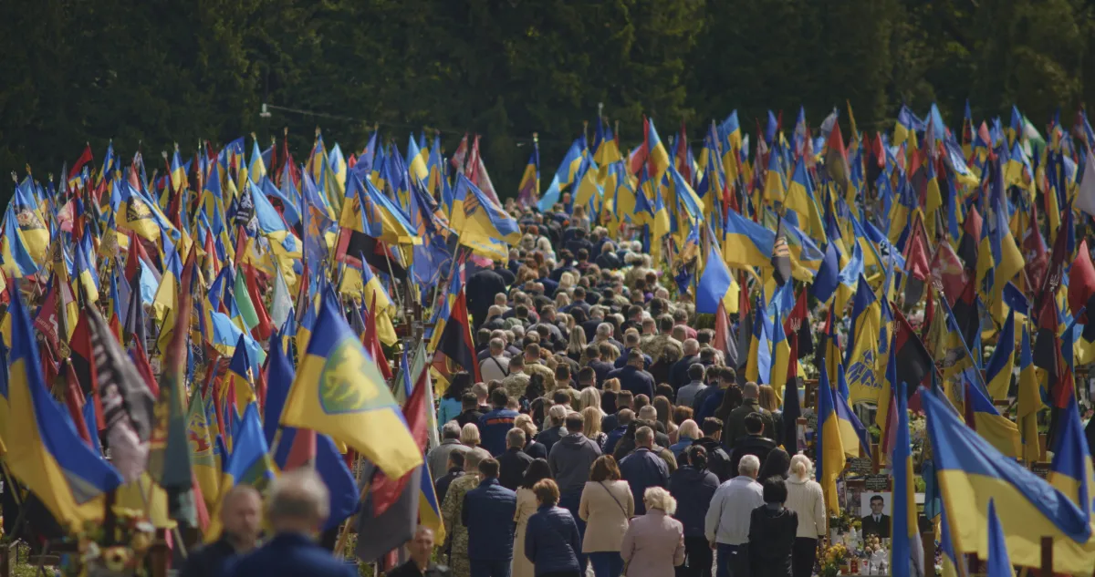 A crowd of people follows the coffin of a fallen soldier being buried at the Field of Mars military cemetery in Lviv.