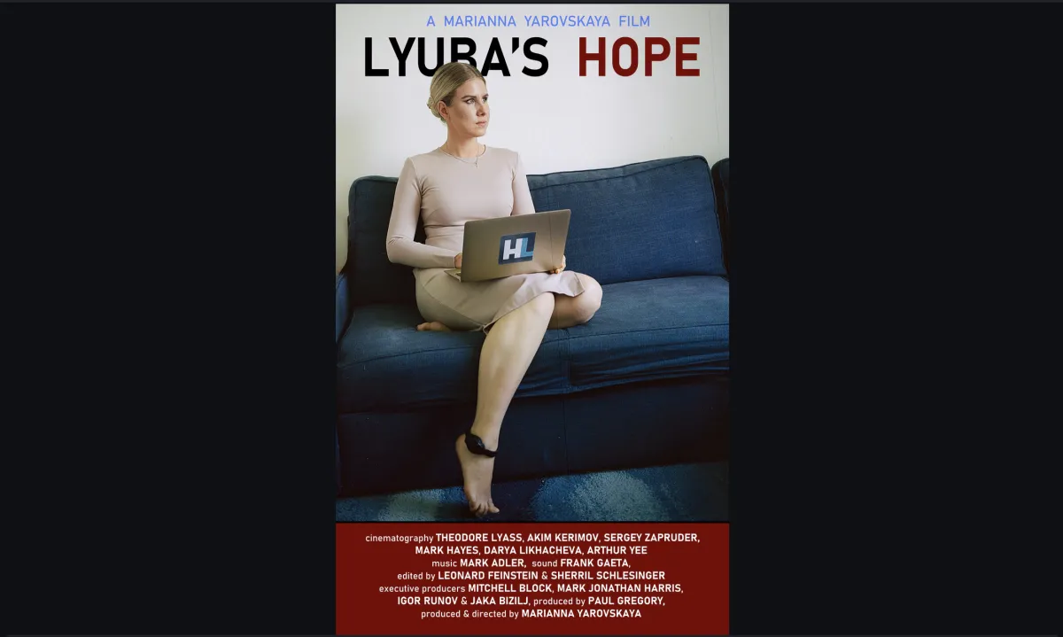 Film poster showing a blonde woman sitting on a couch with an ankle monitor on, holding a laptop.