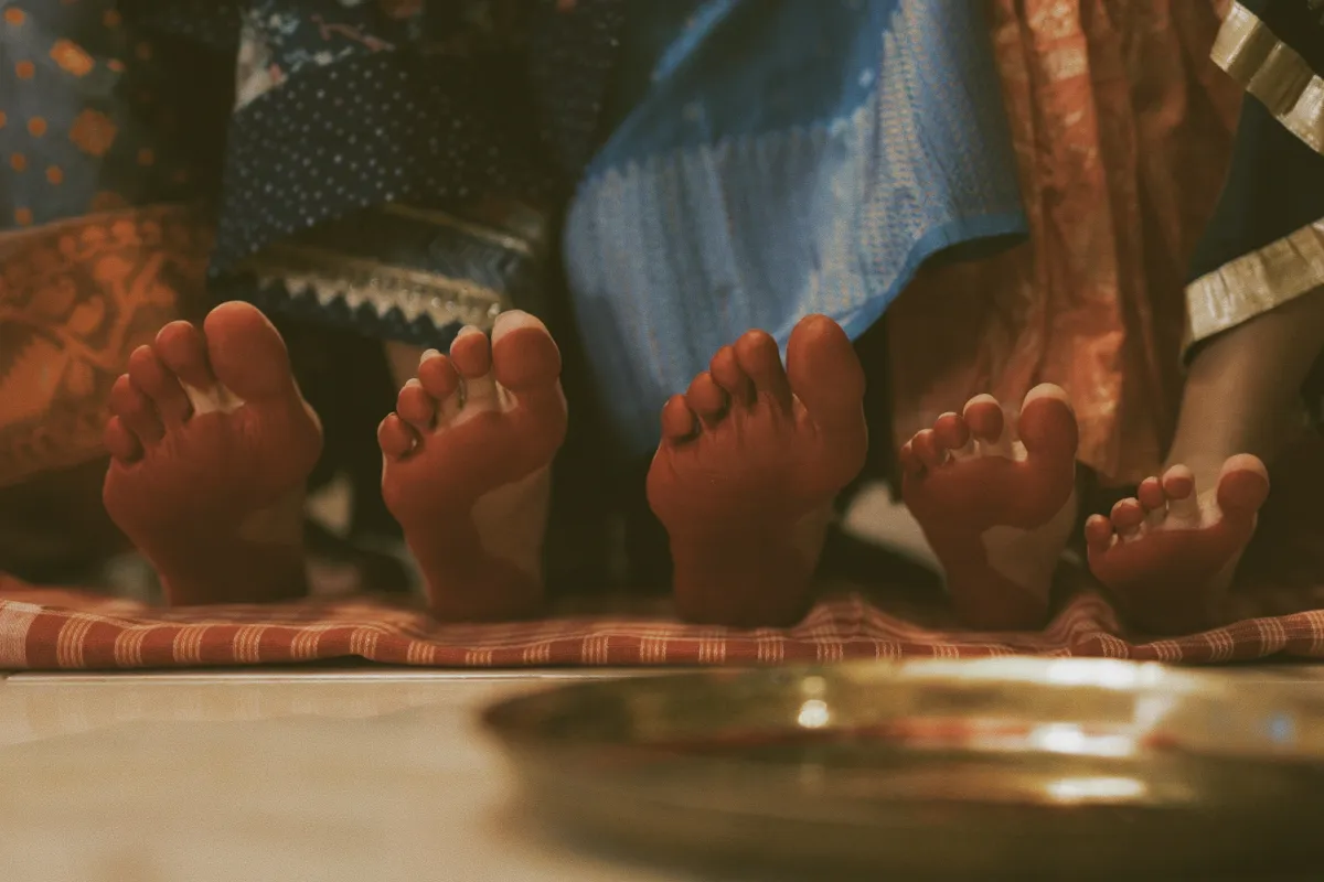 The right foot of five different girls and women with toes pointing upward to reveal the soles of their feet, which have been dyed red.