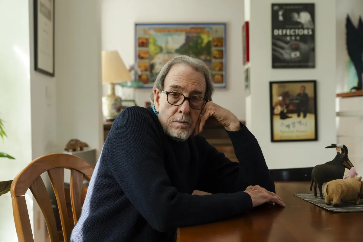 A white man sits at his dining room table.