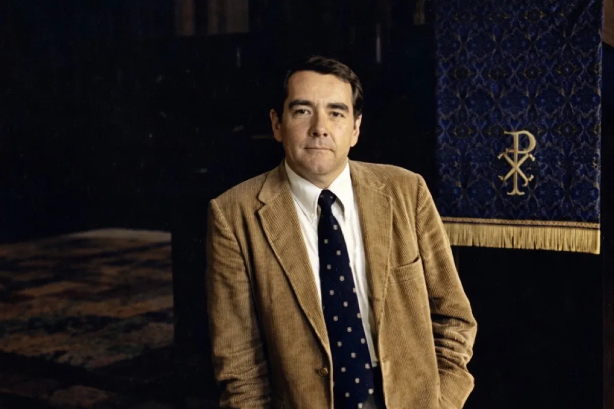A picture of Rev. Raymond Judd Jr. in the late 1970's, standing next to the pulpit in the Trinity Chapel that he preached on for over 30 years.