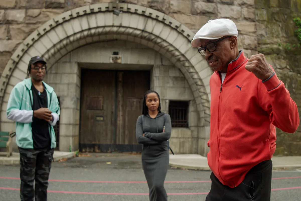 Experiment Survivor Herbert Rice stands in front of Holmesburg Prison with his grandchildren