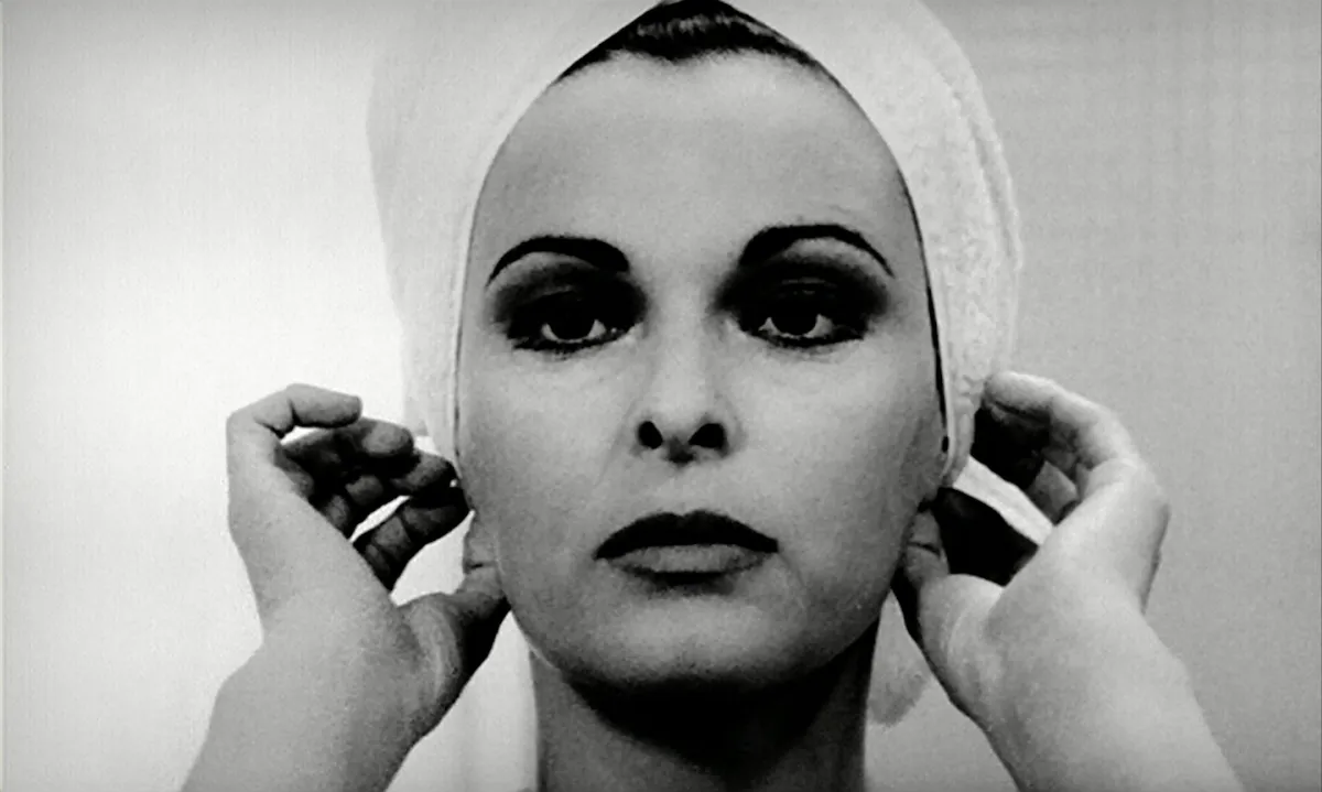 Black and white close-up of a beautiful white woman with lipstick as she adjusts the towel in her hair with her hands