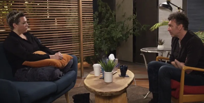 2 people sitting across from each other coffee table between them