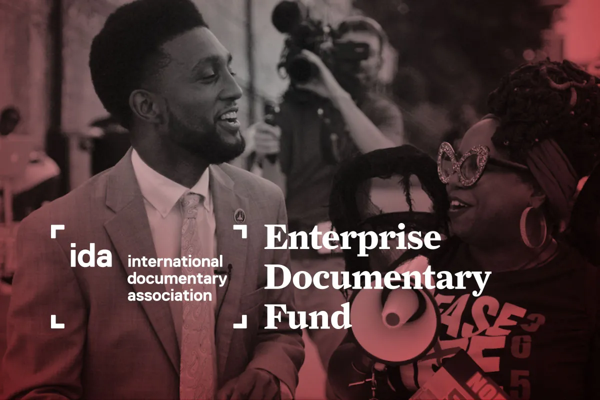 A camera person films a Black man and a Black woman walking together at a protest. A behind the scenes shot from 'Untitled Baltimore Documentary Project' by Gabriel Francis Paz Goodenough