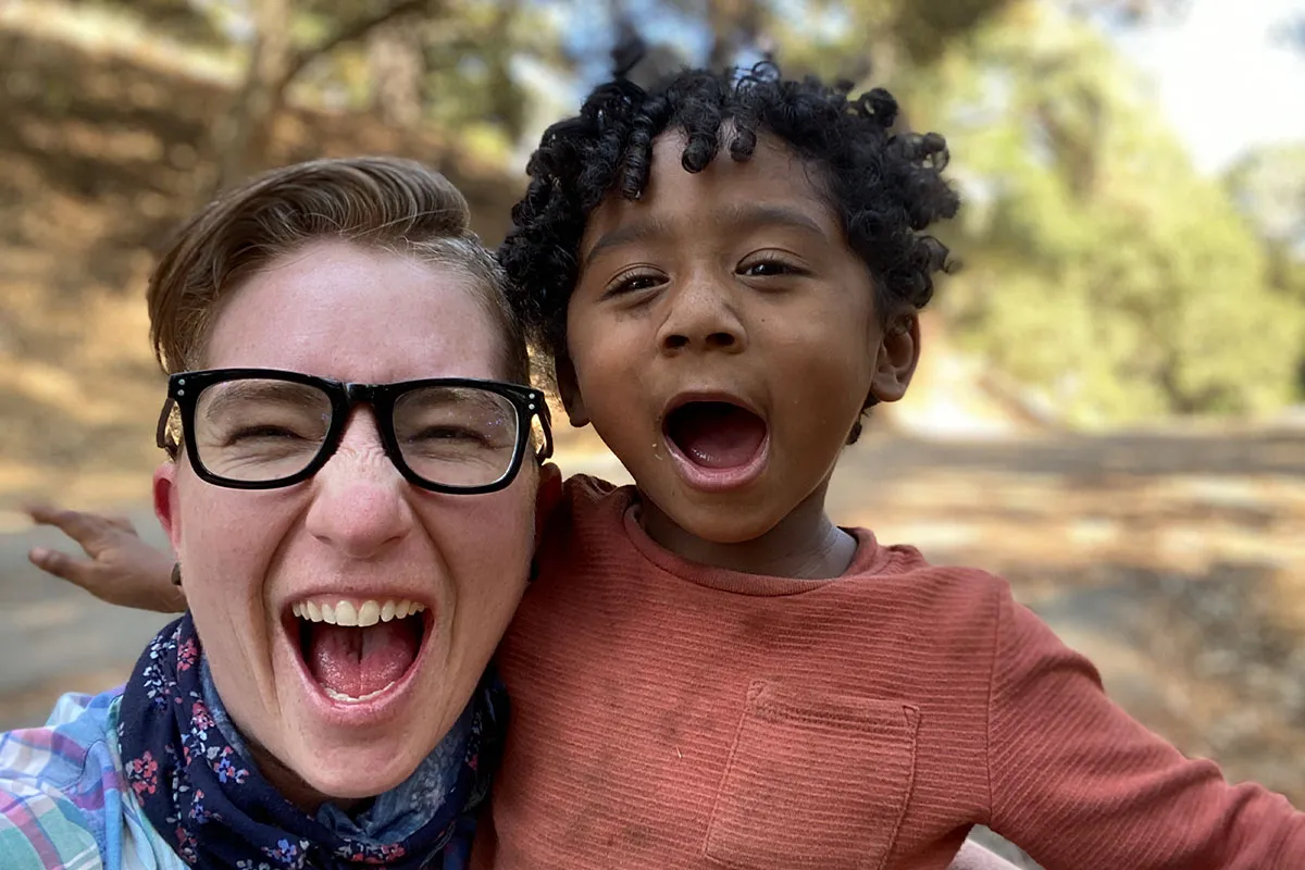 Filmmaker Nico Opper and their baby, Jonah making faces at the camera. Opper is wearing black-rimmed glasses and Jonah, an orange shirt. Courtesy of Nico Opper.