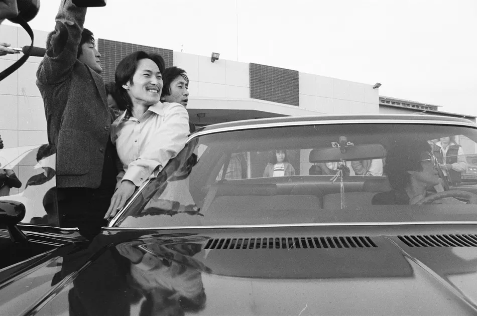  A black-and-white photo shows Chol Soo Lee, an Asian American man, smiling outside of a car after being released from prison, From Julia Ha and Eugene Yi's ‘Free Chol Soo Lee.’ Photo courtesy of Grant Din/ITVS.