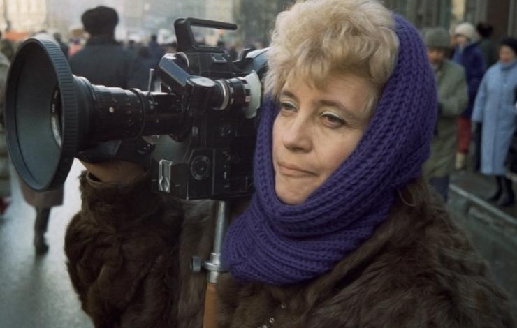 Marina Goldovskaya wears a fur coat and holds a camera.