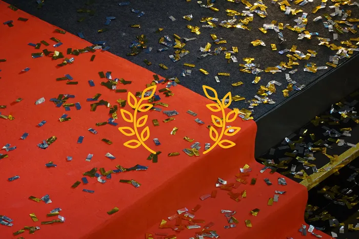 a red carpet on the steps with confettis on the floor.