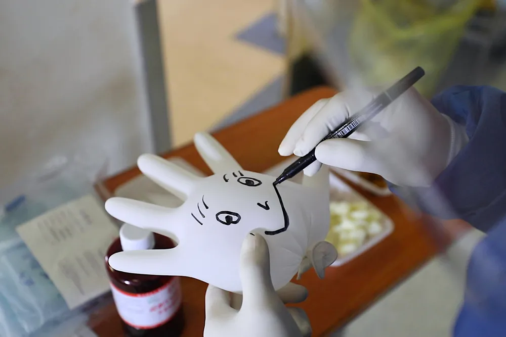 Someone is drawing a smiley face on a blown-up glove