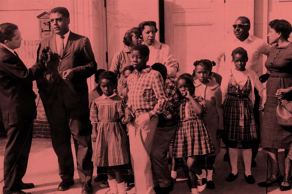 Civil rights attorney Paul Zuber being interviewed outside Roosevelt school with parents and children who were refused registration, New Rochelle, 1960.