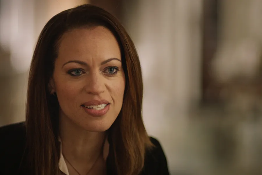 A Black woman with straight dark brown hair