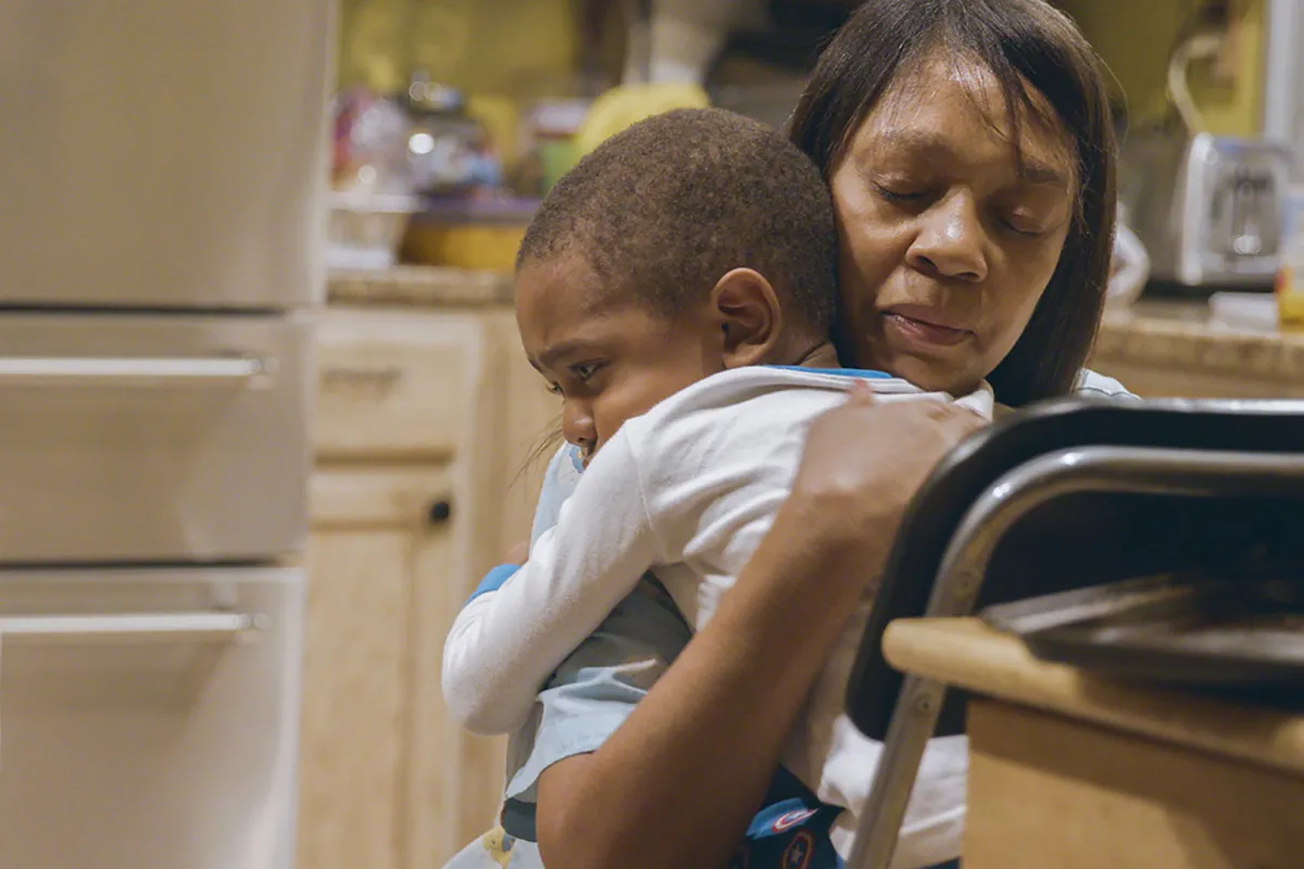 A Black woman is holding a toddler