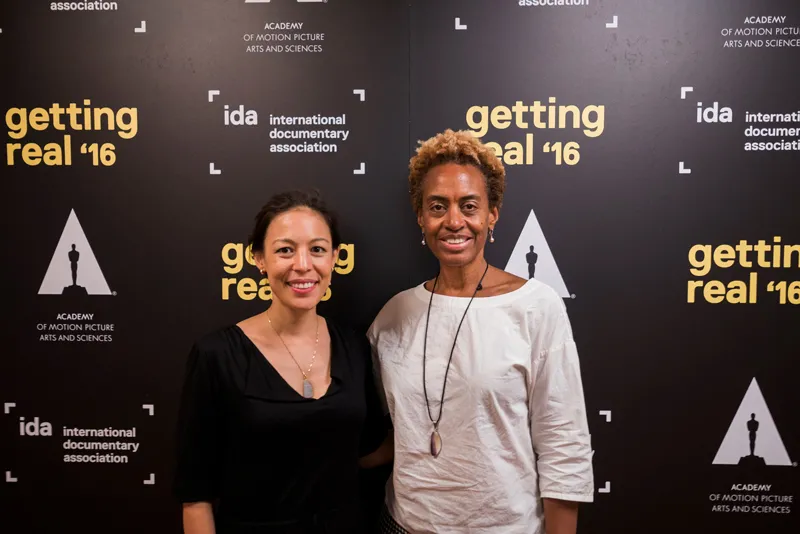 Marcia Smith (right) posing with Sonia Kennebeck (left) in front of step and repeat with IDA, Getting Real '16 and Academy of Motion Picture Arts and Sciences logos.
