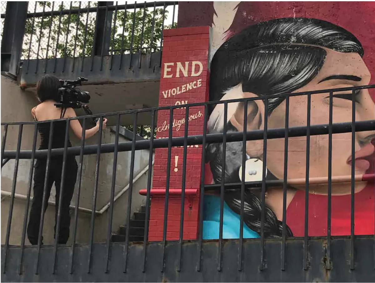 filmmaker filming mural of indigenous woman