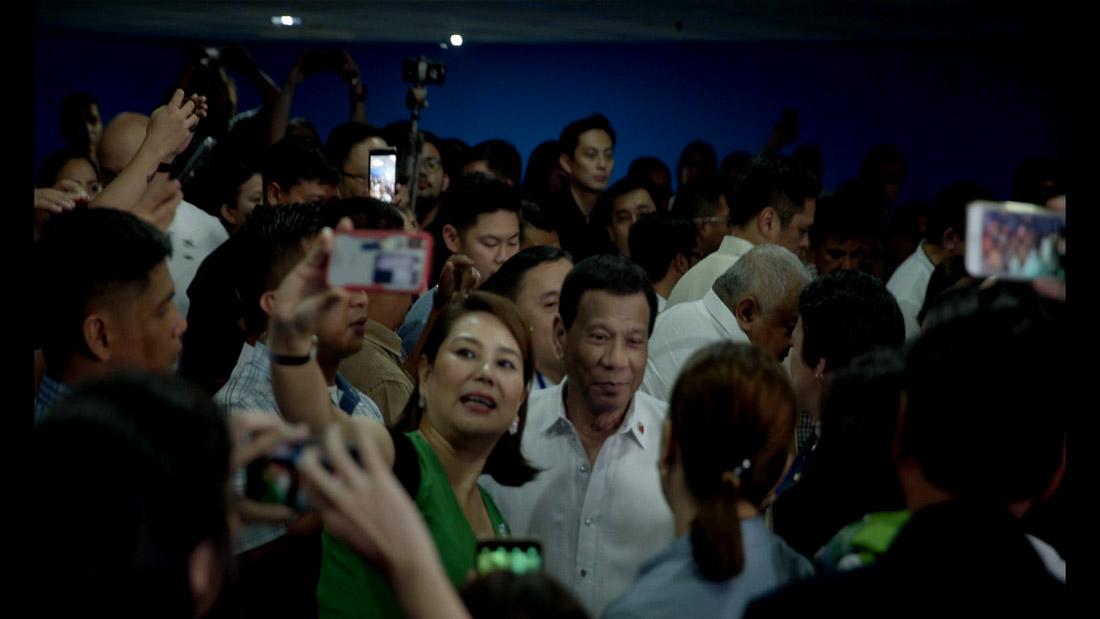 Crowds surrounding a Filipino man