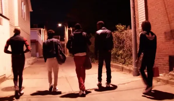 group of LGBTQ+ gang members walk down alley at night