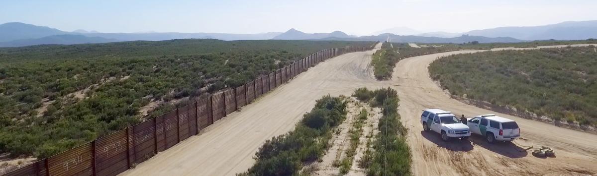 The US-Mexico border, patrolled by the green Border Patrol SUVs