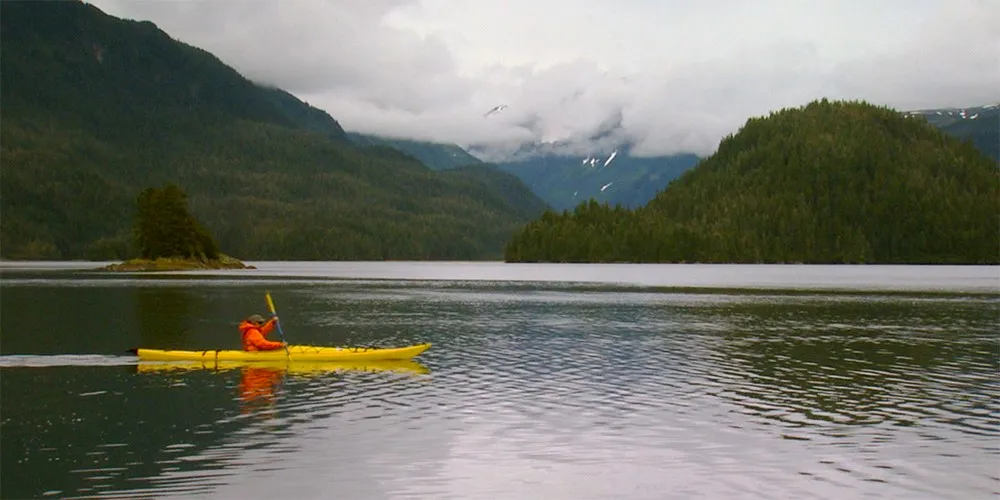 yellow kayak glides across large lake