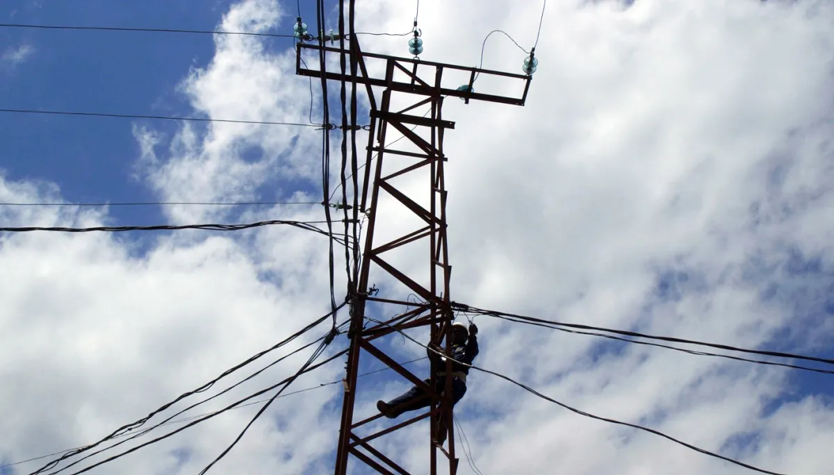 line worker works on electric tower in the Congo