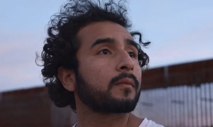 Javier Zamora stands near the wall built on the USA - Mexico Border as he searches for the place through where he crossed as a child. 