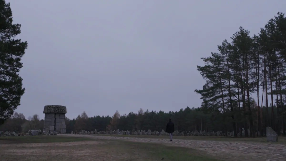 Treblinka Monument at a distance with a figure walking through the stones.