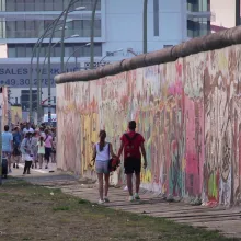 A young couple walks along a preserved segment of the Berlin Wall in 2014