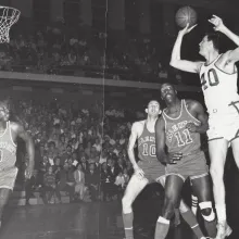 Black and white image of Scranton Miners center Bill Spivey, a 7'2" white man wearing a white jersey with the number 40 on it, shooting a basketball during a game against the Allentown Jets