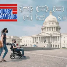 A woman, and a man in a wheelchair, in front of the US Capitol Building.