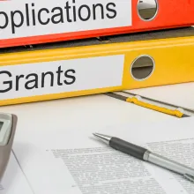 Image of two binders labeled Applications and Grants