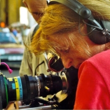 Photograph of Claire Simon looking through a camera viewfinder.