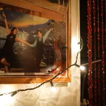 Image of a photo board on the wall, with a picture of a dancing couple pinned onto it, and string lights in the foreground