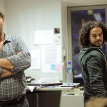 Still image from 'Life Is Beautiful,' depicting filmmaker Mohamed Jabaly operating a camera and looking over his shoulder.