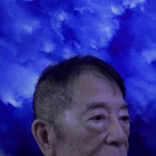Still from 'Nowhere Near,' depicting the upper half of a Filipino man's head in front of a blue background. Courtesy of the Flaherty.