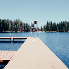 Lake Sequoia framed by trees, with boat docks and lifeguard chair in the foreground.