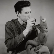 Black and white image of Jim Henson with a Kermit puppet.