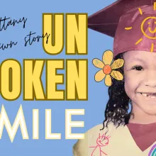 A young Brittany Chrishawn with her two front teeth missing while wearing a kindergarten graduation gown and hat. There's also text on the page that reads "Unbroken Smile"